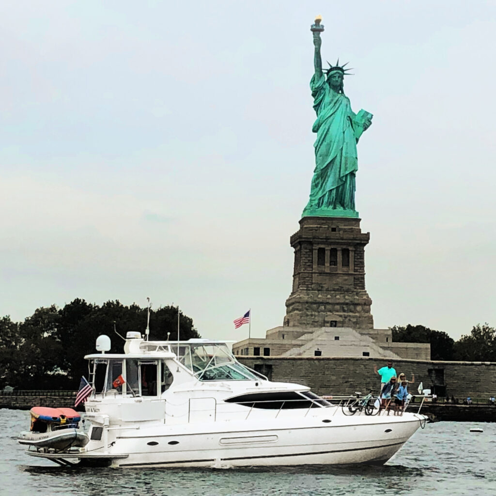 a boat in front of the statue of liberty