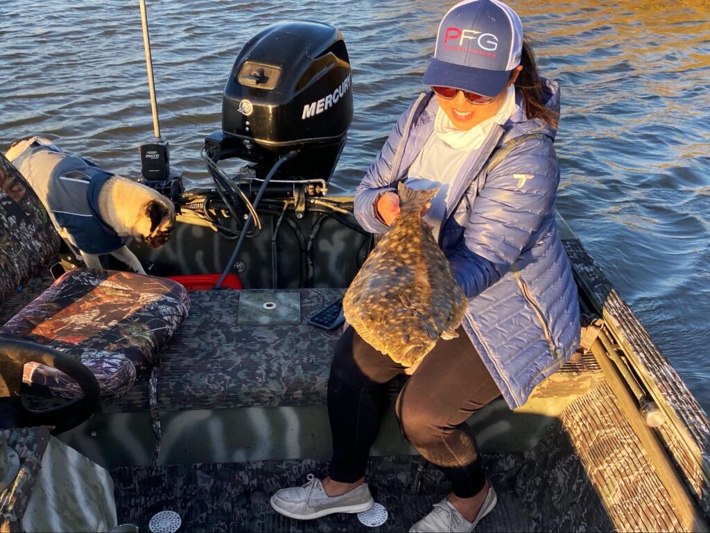 a woman poses with fresh caught flounder